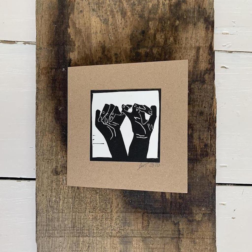 Bouclé signature interlinked hands logo printed on a handmade card. It has the pinky promise symbol in a graphic black and white print on reycled card blank inside for your message
