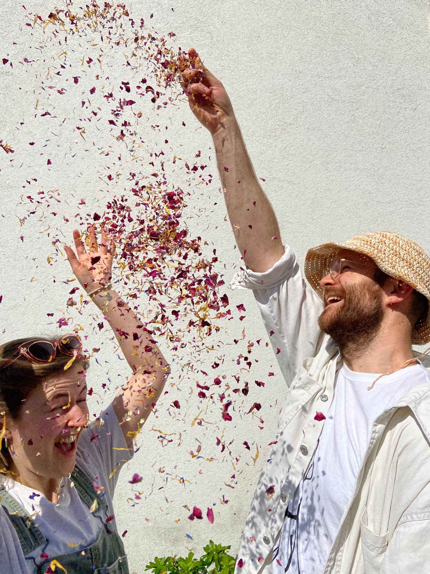 Eco dried flower confetti being thrown for wedding styling photo. The petals are colourful and beautiful and plastic free.