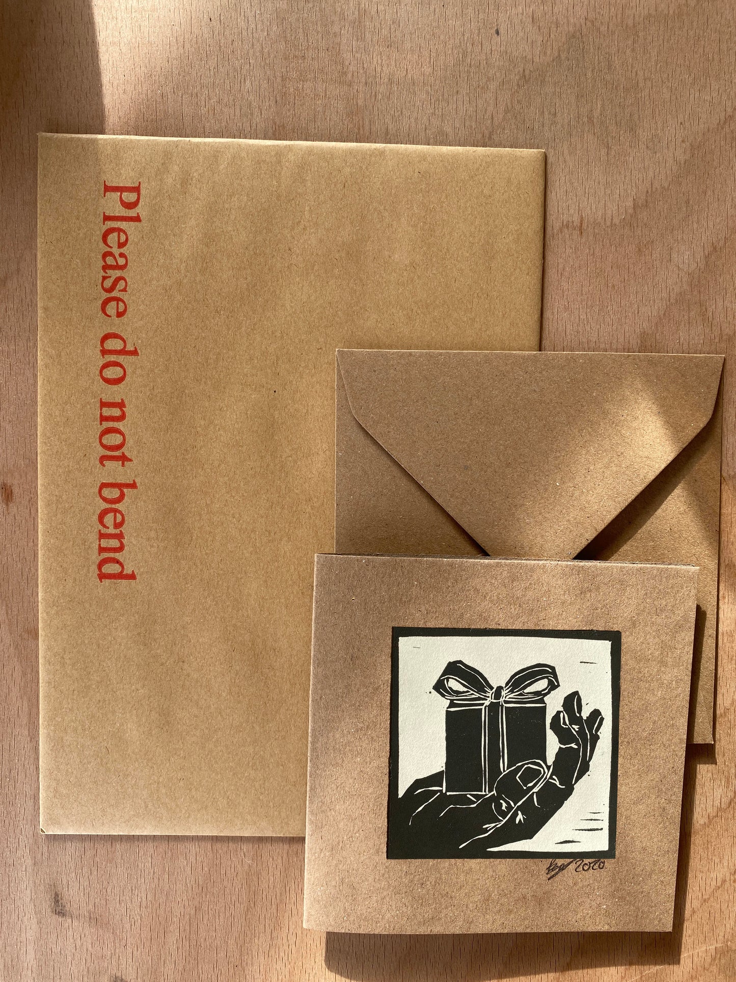 Hand made greetings card blank inside for your message. Made in the UK with a gift in hand design on the front.
