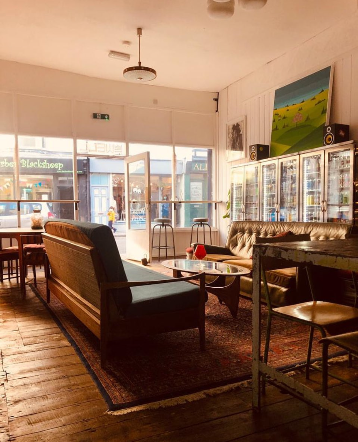 Interior of a cafe with wooden furniture and large windows.