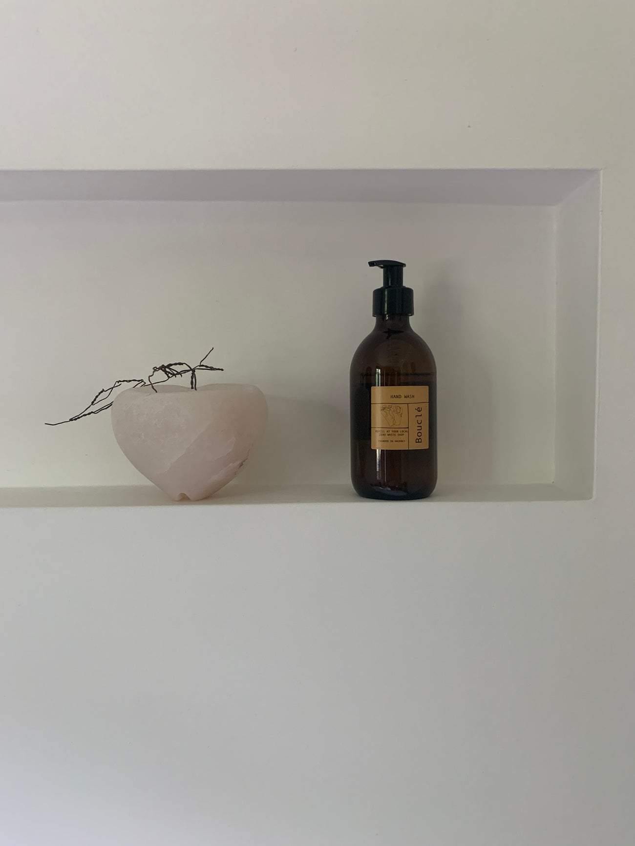 Bouclé London hand wash amber glass bottle on bathroom shelf