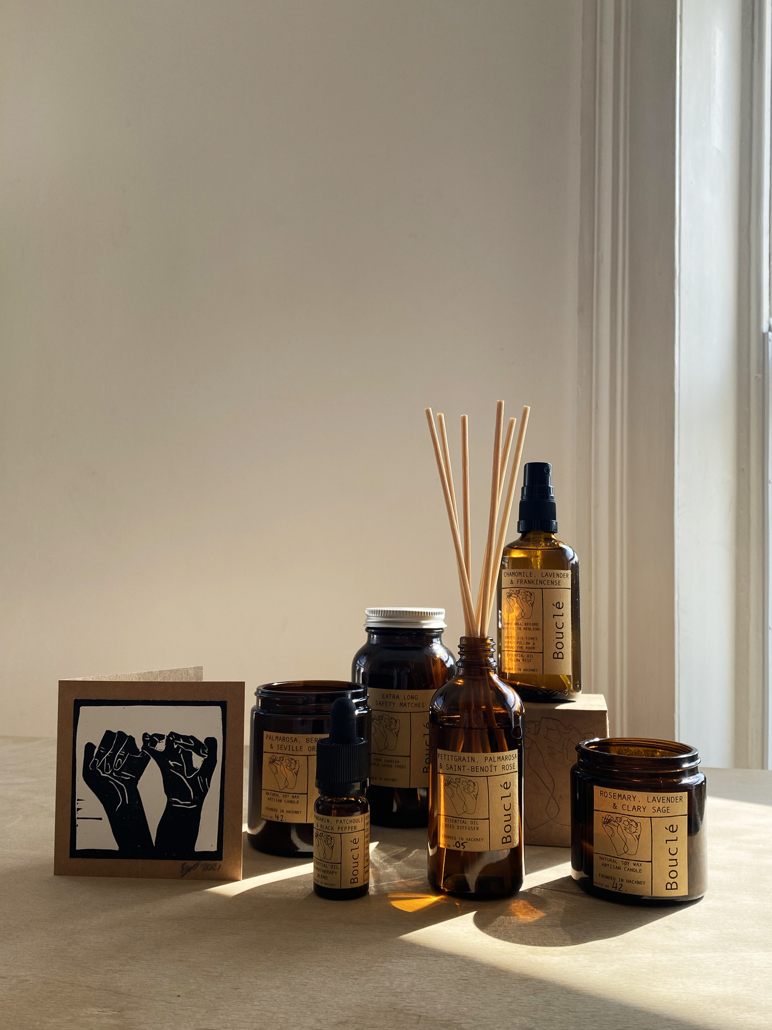Selection of Bouclé London essential oil home fragrance products including soy candles, room sprays and essential oil blends complete with a hand printed card making it the perfect gift for her. 