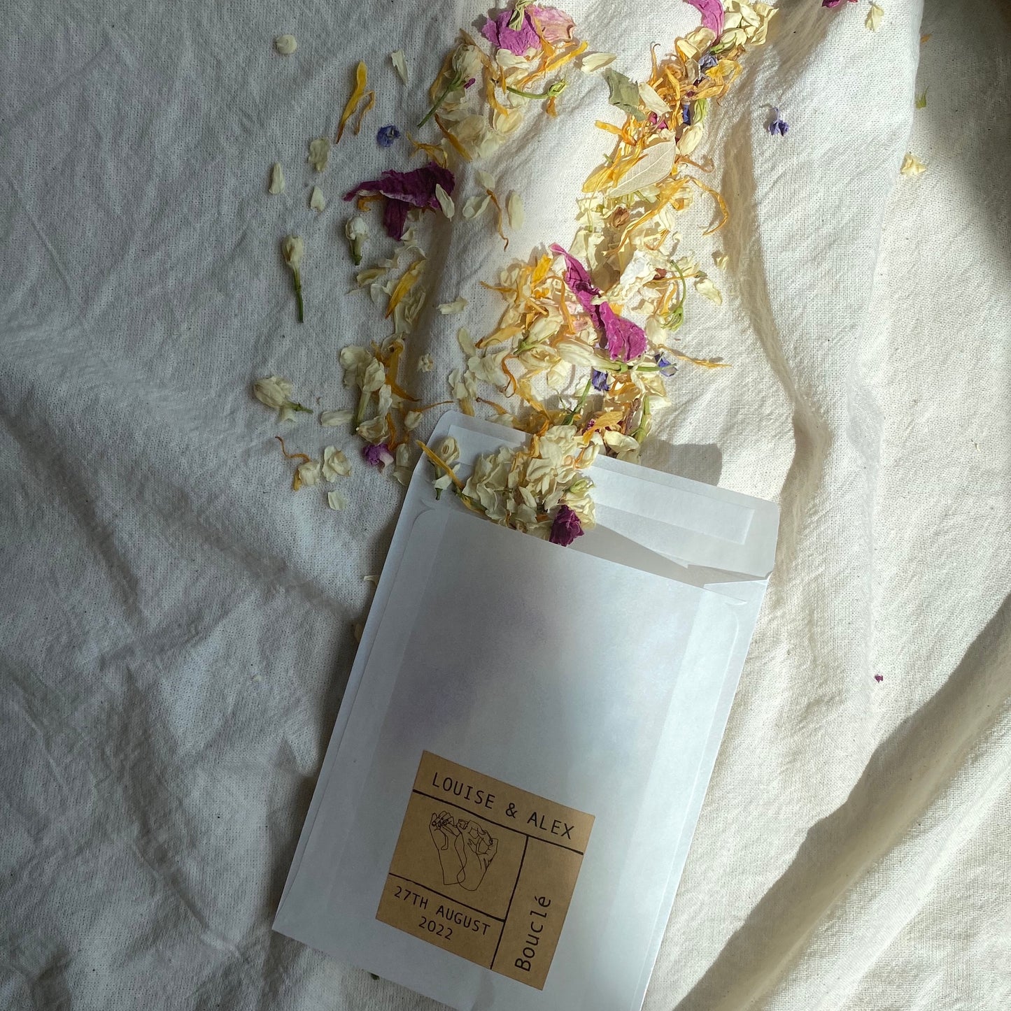 Natural eco real petal confetti made from dried flowers. In a personalised recyclable and biodegradable pouch for wedding styling and wedding photos. The colours are cream, blush and rose pink.