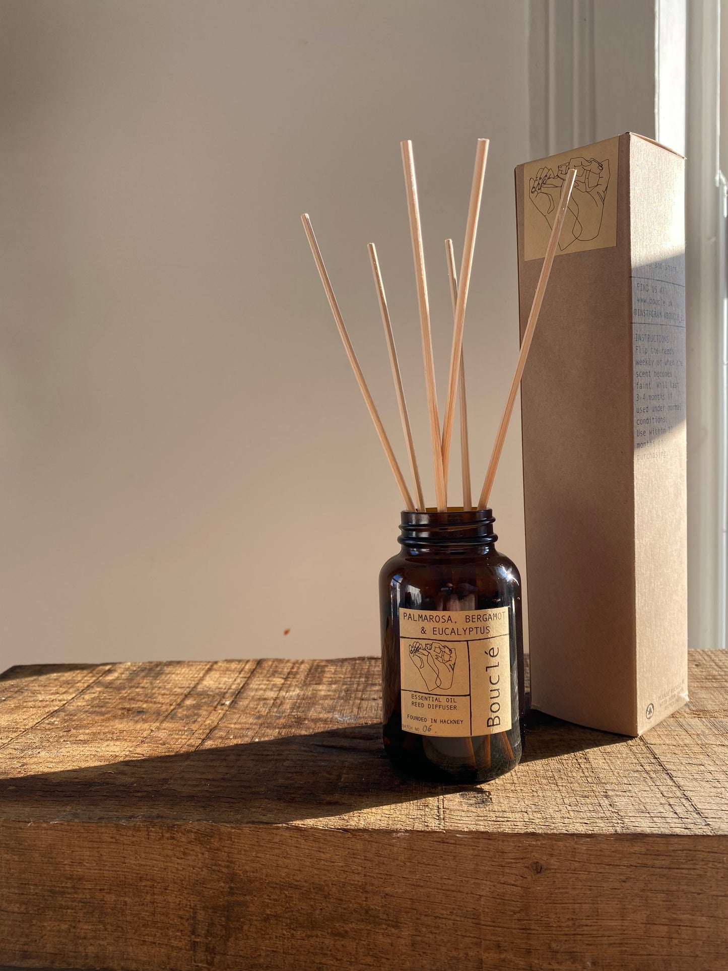 Bouclé London reed diffuser in amber glass jar for all natural flame free fragrance. Diffuser sticks in the sun.