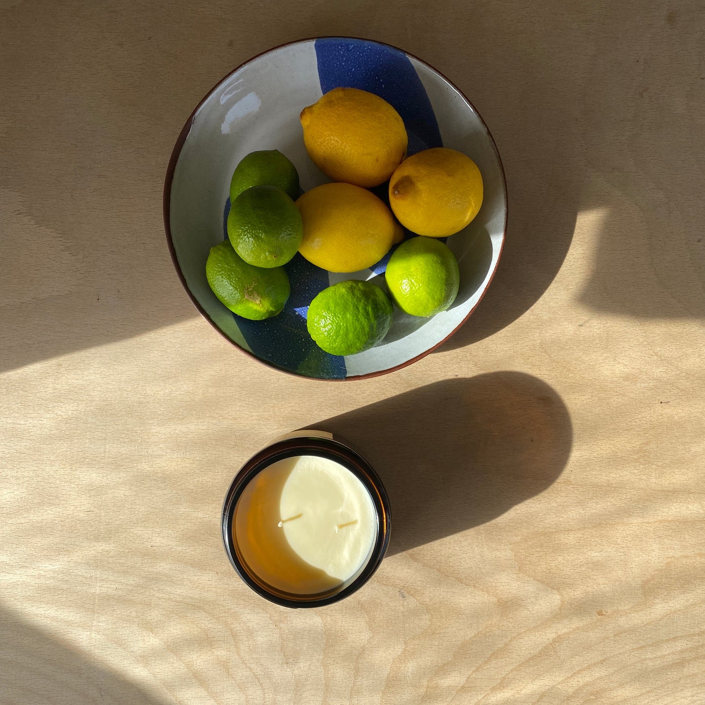Extra large double wick soy wax London candle next to fruit bowl.