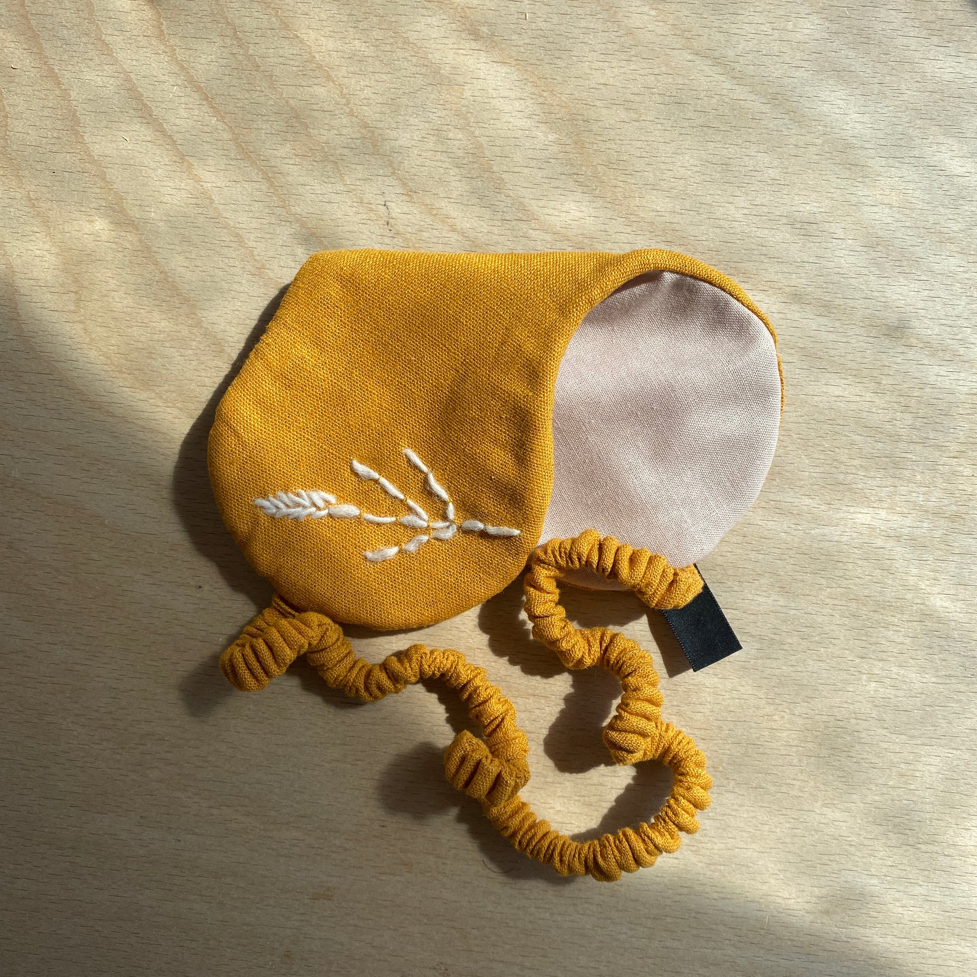 Hand made in East London and Brighton this eye mask is made using ochre linen and is finished with a hand embroidery.