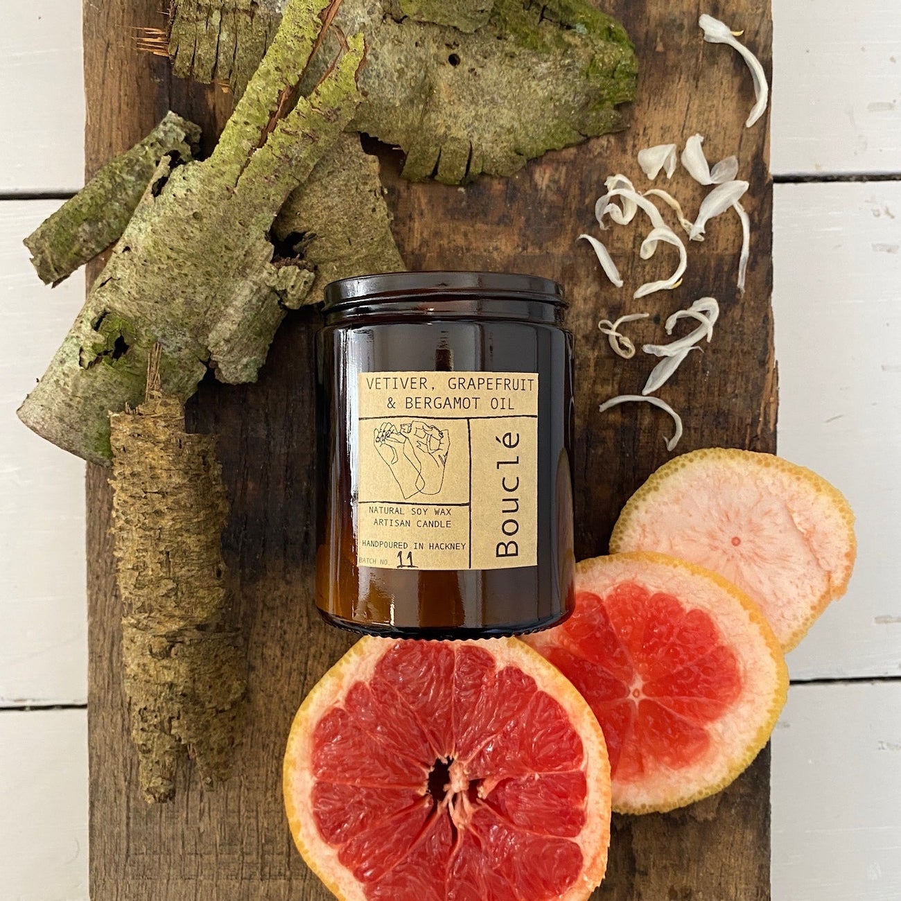 Vetiver, Grapefruit & Bergamot aromatherapy candle with natural ingredients beside it. Made in East London & Brighton.