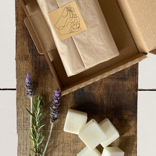 London soy wax melt monthly subscription box wrapped in tissue paper next to lavender and rosemary sprigs.